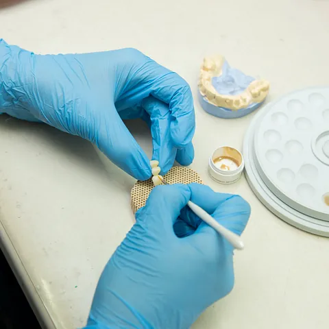 mujer sosteniendo dentadura